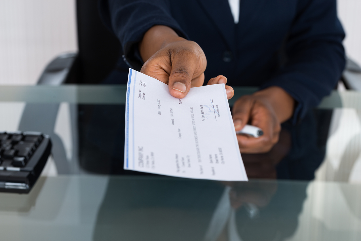 Close-up Photo Of Person's Hand Giving Check