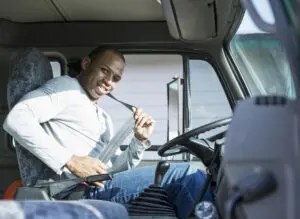 truck driver smiles as he puts on his seatbelt