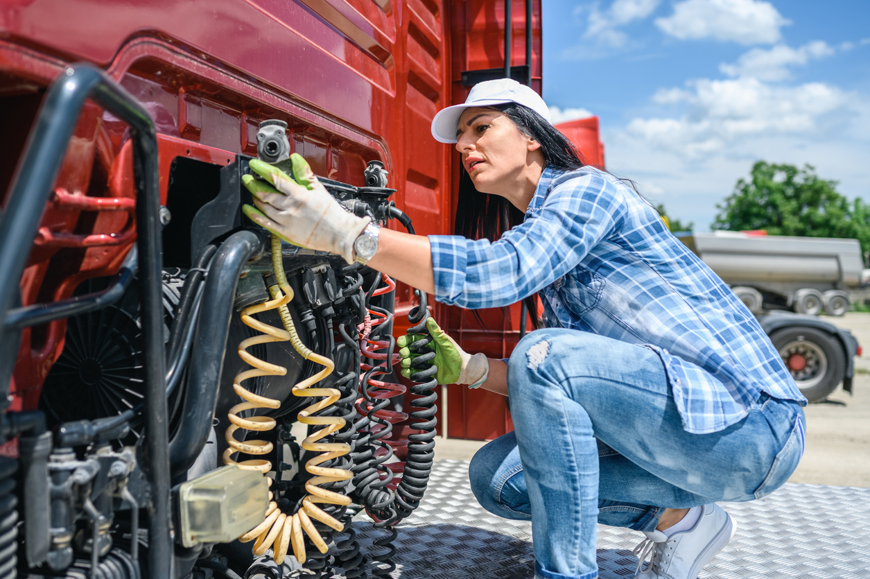 The professional female truck driver checks the correctness of the truck