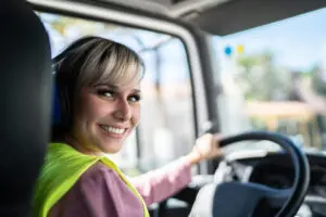 Portrait of a female trucker driver inside the truck at a construction site