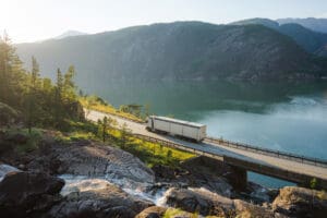 Scenic view of truck on the road near the waterfall that falls into fjord in Norway
