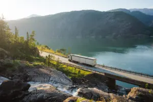 Scenic view of truck on the road near the waterfall that falls into fjord in Norway