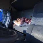 Truck driver sleeping on bed inside truck cabin to show truck driver sleep habits